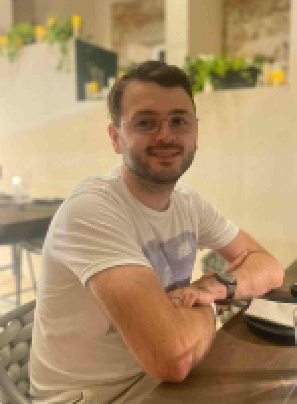 Rens smiling while seated at a table
